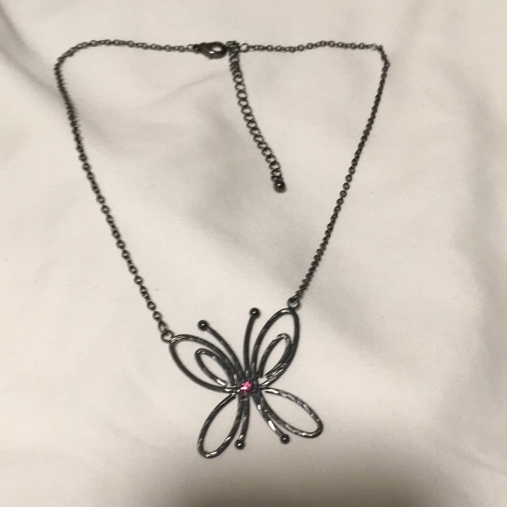 Butterfly necklace with purple stone in center with dark metal chain.